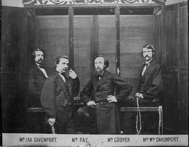This 1870 photograph shows the brothers and William Fay in front of the “spirit cabinet”.