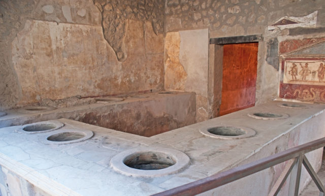 Marble surface counter of Thermopolium of Asellina – the holes in counter serve for jugs with food and wine, Pompeii.