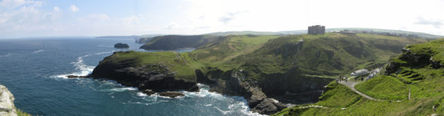 Panoramic view from Tintagel Castle, looking north-east; the prominent building is a hotel, built in 1899, now called the Camelot Castle Hotel; the headland below is Barras Head. Photo by Michal Stehlík CC BY-SA 2.0