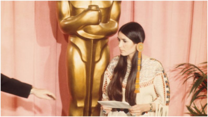 Sacheen Littlefeather holds a written statement from actor Marlon Brando refusing his Best Actor Oscar on stage at the Academy Awards on March 27, 1973 in Los Angeles, California. (Photo by Michael Ochs Archvies/Getty Images)