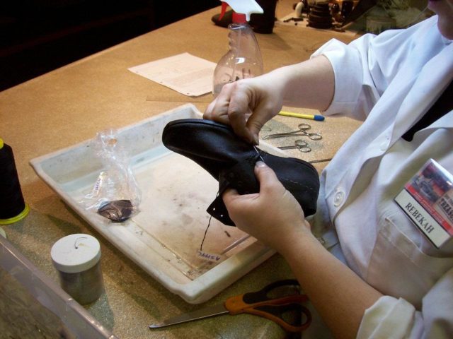 Preservationist restitching a shoe in the Arabia Steamboat Museum’s preservation lab. (Photo Credit: Prosekc / Wikimedia Commons / CC BY-SA 3.0)