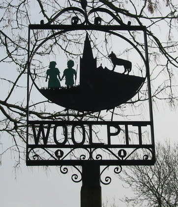 Village sign depicting the two green children, erected in 1977. Author: Rod Bacon CC BY-SA 2.0