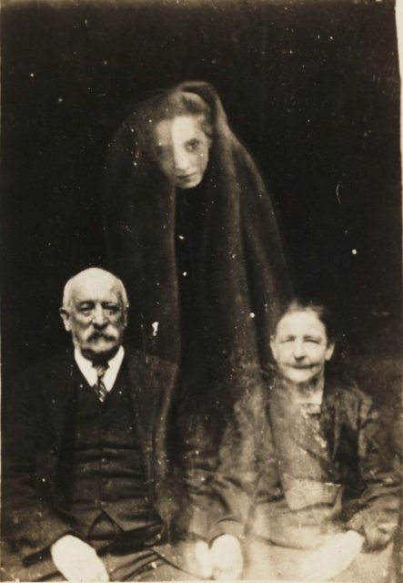This is an image of a couple with a young female spirit. According to the image, it seems to be created to support Spiritualism in the 19th century. It was taken by the spirit photographer William Hope.