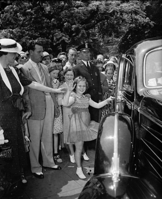 Shirley Temple leaving the White House offices with her mother and her bodyguard, John Griffith, 1938