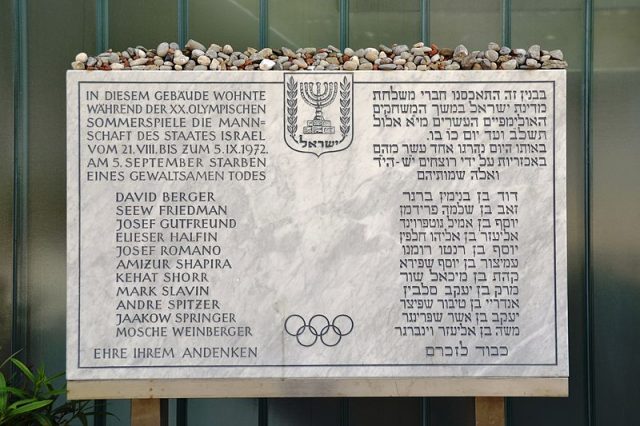 Memorial plaque in front of the Israeli athletes’ quarters. The inscription, in German and Hebrew, translates as:”The team of the State of Israel stayed in this building during the 20th Olympic Summer Games from 21 August to 5 September 1972. On 5 September, [list of victims] died a violent death. Honor to their memory.” Author: High Contrast CC BY 3.0