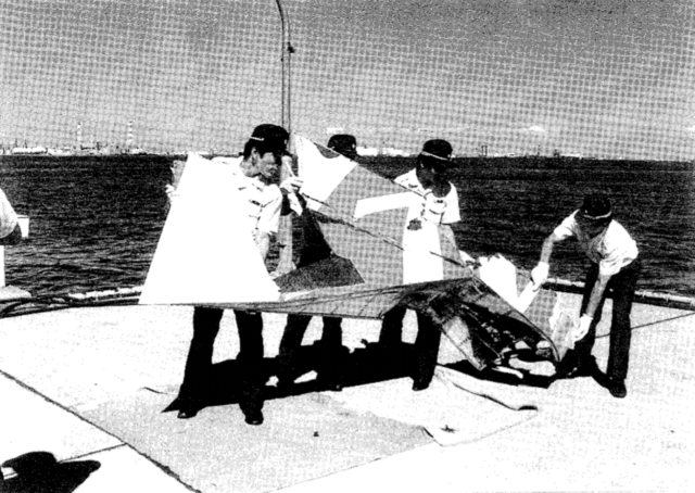 Four men carrying a piece of the vertical fin of Japan Air Lines Flight 123