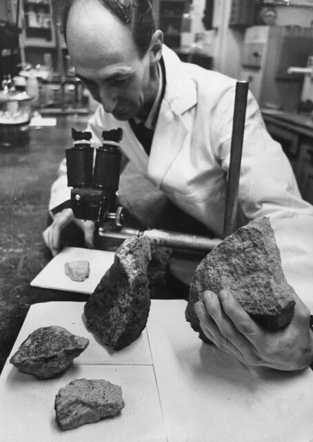 a scientist examines the meteorite
