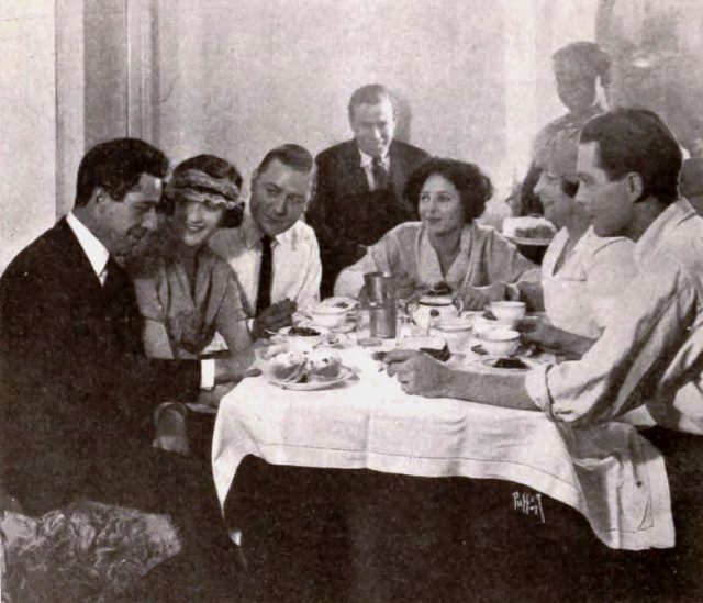Norma Talmadge having lunch in her dressing room with her director Chester “Chet” Withey, Constance Talmadge, Kenneth Harlan, studio executive Eddie Mannix, Harrison Ford, and “Lilly”, on page 72 of the January 1, 1921 Exhibitors Herald.