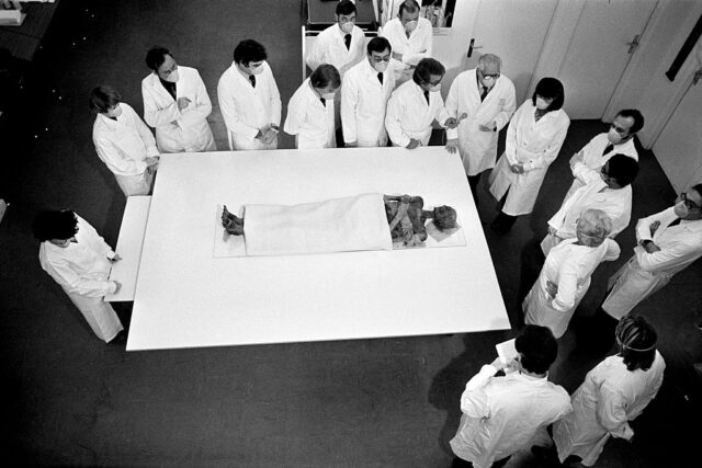 Experts standing around a table with Ramesses II's body placed atop it