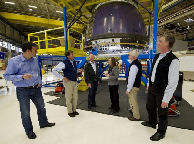 Bezos giving NASA Deputy Administrator Lori Garver (fourth from left) a tour of Blue Origin’s crew capsule.