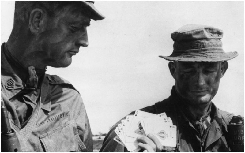 16th January 1967: Two US Marine sergeants getting a supply of Ace of Spades cards, known as the 'death cards' which the reconnaissance forces leave as a warning to the Viet Cong, before going on patrol in enemy territory. (Photo by Keystone/Getty Images)