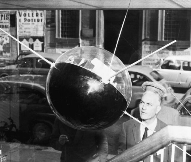 A man looks at a Sputnik replica.