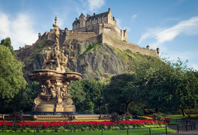 Edinburgh, UK – September 18, 2012: Flowers surrounding the ornate Ross Fountain in Princes Street Gardens in Edinburgh, with Edinburgh Castle in the background.