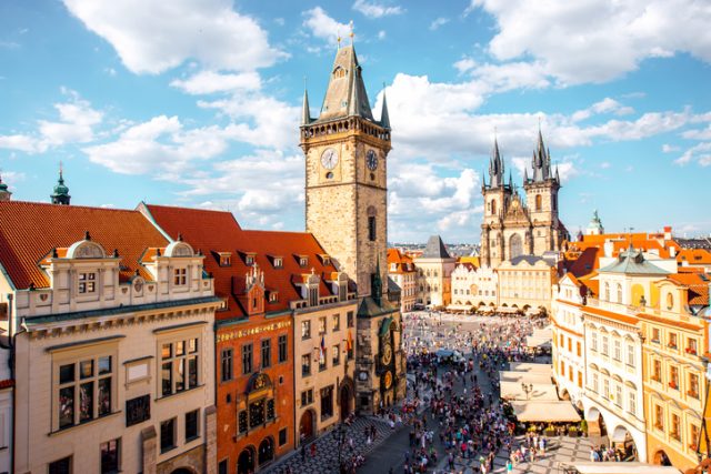 Cityscape view on the clock tower and Tyn cathedral on the old square in Prague.