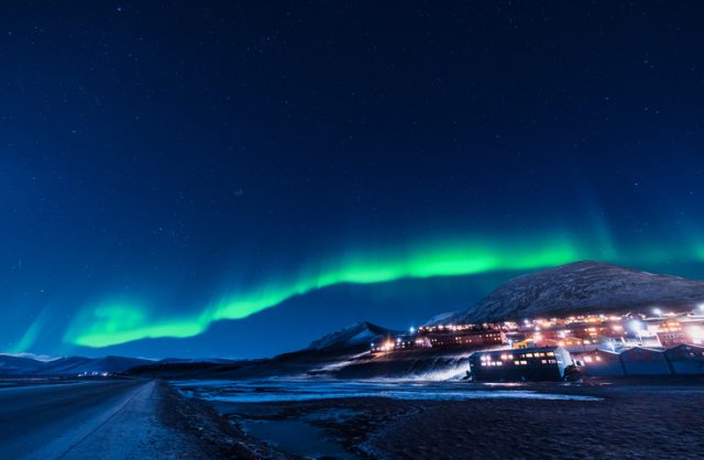 The polar arctic Northern lights aurora borealis sky star in Norway Svalbard in Longyearbyen city the moon mountains