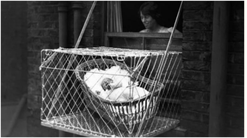 Baby in Cage Hung Out of Window (Photo by © Hulton-Deutsch Collection/CORBIS/Corbis via Getty Images)