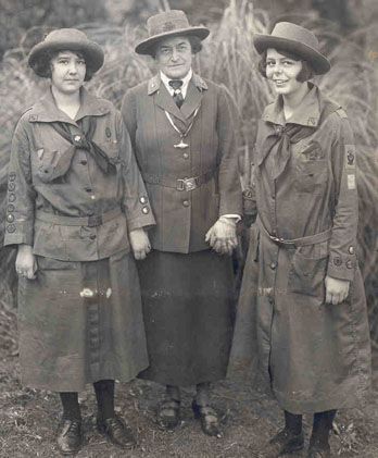 Juliette Gordon Low (center) standing with two Girl Scouts, Robertine McClendon (left) and Helen Ross (right)