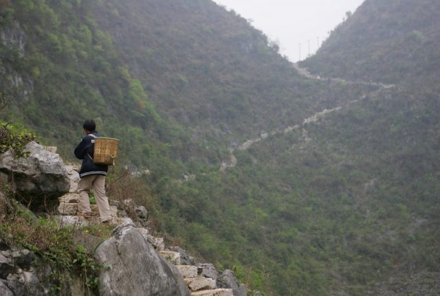 A villager walks from the Middle Cave, home to a community and school, to town on the weekly market day (Photo by Cancan Chu/Getty Images)