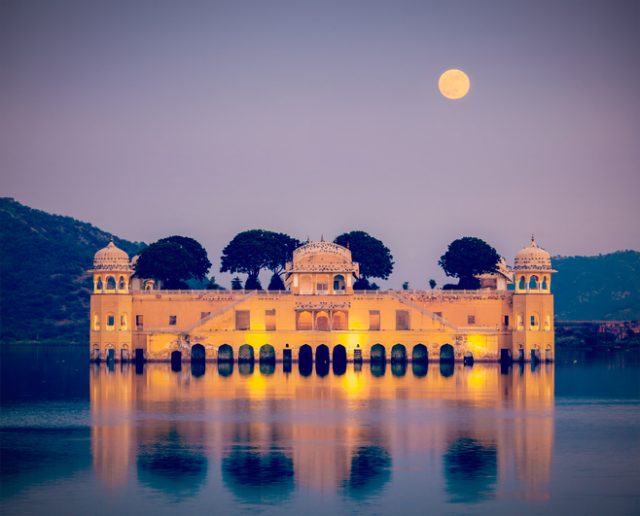 Vintage retro hipster style travel image of Rajasthan landmark – Jal Mahal (Water Palace) on Man Sagar Lake in the evening in twilight. Jaipur, Rajasthan
