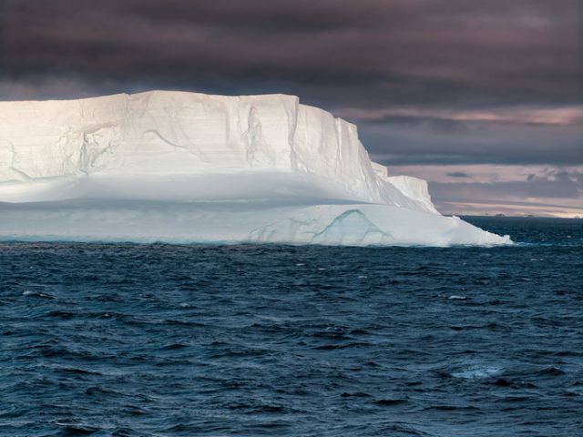 Huge Tabular Iceberg floating in Bransfield Strait at sunset, Antarctica