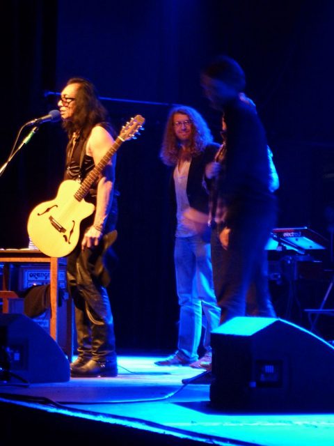 Sixto Rodriguez at Manchester Academy,  December 2012 (he finally took off his hat at the end of the show)Photo: Jake from Manchester, UK – CC BY 2.0