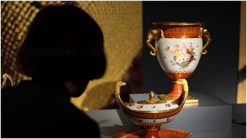 An employee poses with pieces from the 'Marly Rouge' porcelain service set made for Napoleon I, circa 1807-1809 (estimate $150,000 - 250,000) during a photocall for the Peggy and David Rockefeller art collection at Christies auction house (Photo by Jack Taylor/Getty Images)