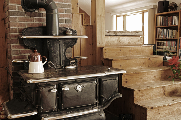 An old cast-iron cook stove is the perfect accessory in this rustic-look modern home. Note the iron waiting to be heated up.