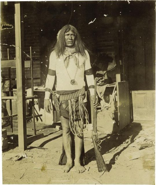 A barefoot Apache with an Evans Repeating Rifle, c. 1880.