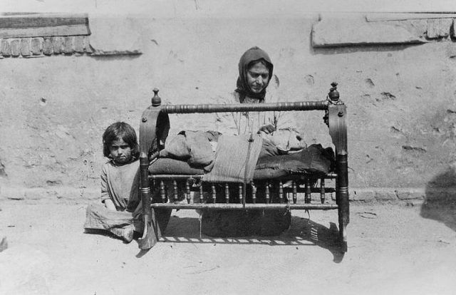 A photo showing an Armenian woman and a baby laid in the cradle.