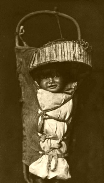 A baby laid in a cradleboard. These traditional baby carriers were designed to be worn on the mother’s back, or secured to a sled or horse saddle.