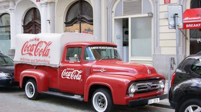 A Ford F100 model delivery truck in classic Coca-Cola red. Photo by Asurnipal CC BY-SA 4.0
