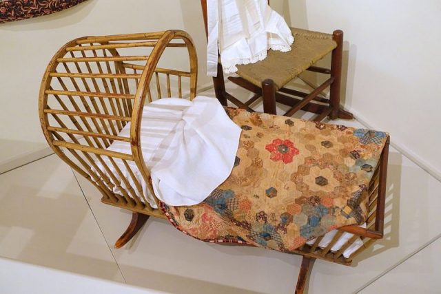 Early 19th century cradle made from pine and hickory, on display at the Concord Museum, MA. The quilt and was handmade by Hannah Dawes Newcomb (1769-1851). Photo by Daderot CC0