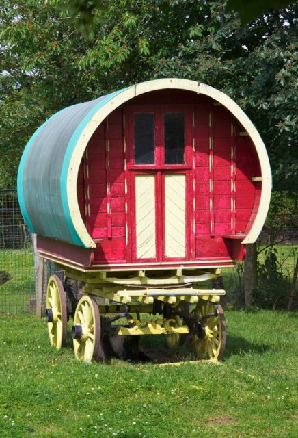 A horse-drawn Bowtop caravan standing in a field in Ireland.