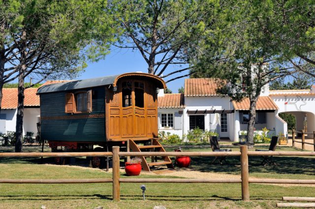 Romani caravan, possibly a Brush wagon, in a front yard, Saintes-Maries-de-la-Mer, France.