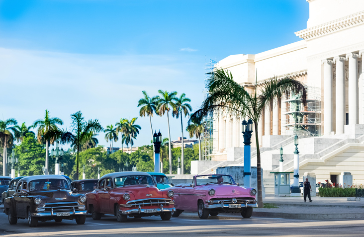 Havana: Street life view with in line american Chevy and Desoto convertible
