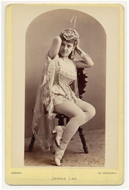 Jennie Lee sitting on a chair holding a headdress. Photo by Dr. Charles H. McCaghy Collection