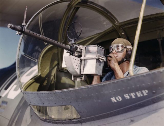 Jesse Rhodes Waller, A.O.M., third class, testing the 30-caliber machine gun which he just affixed on a Navy aircraft.