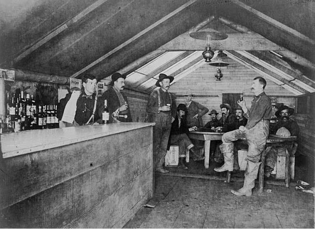 Men gathered for a drink in the Road House Saloon, Bluff City, Alaska, ca. 1906