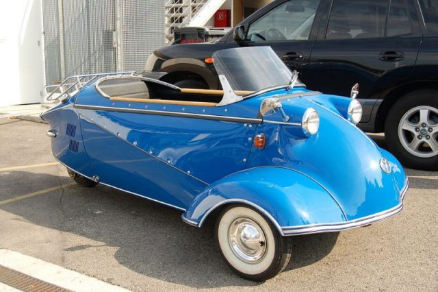 You don’t often get to see one of these in the parking lot. Side view of a blue three-wheeler, Photo by Noebu CC BY 2.5
