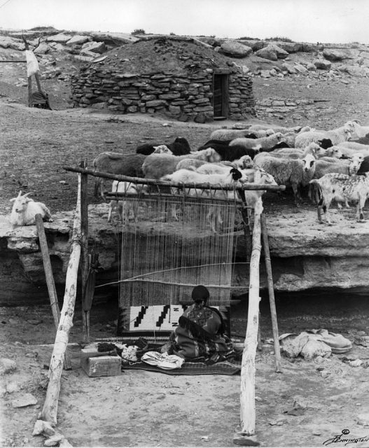 A weaver works at a traditional vertical wooden frame loom. Navajo blankets and rugs are considered some of the most colorful and best-made textiles produced by North American Indians.