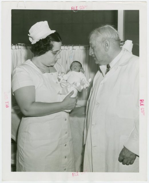 Hildegarde Couney holding baby while Martin Couney looks on. Photo NYPL