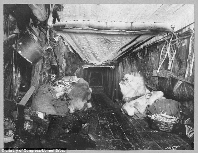Interior of an Inuit hut, 1916, with the wooden ceiling lined with animal skins. There are plenty of furs, snowshoes and mukluk ready for a trip outside.