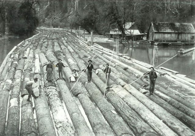 Lumberjacks pose on a timber raft in Washington.