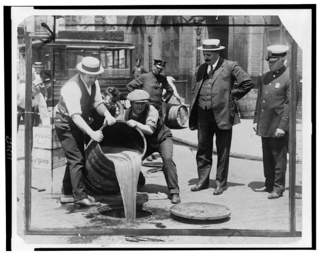 New York, at the peak of Prohibition Era. Liquor is thrown into the sewer. Officers are watching on the side.
