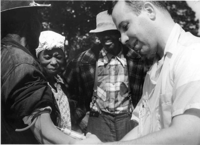 An image from the notorious Tuskegee Syphilis Study: a health officer is taking a sample of blood from one participant, c. 1932.