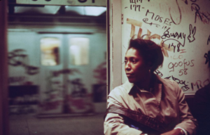 A woman rides in a graffiti covered subway train