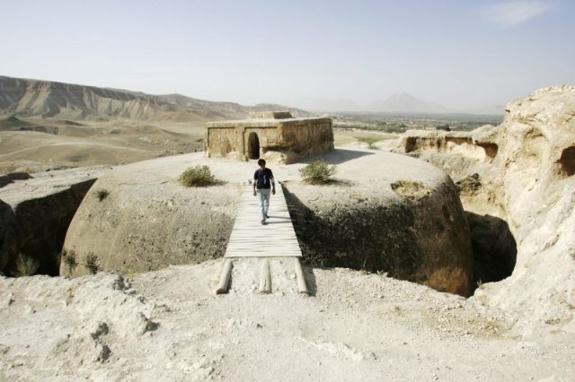 Members of a French archaeological team walk on top of a giant 4th century Buddhist stupa cut into a mountain, on October 11, 2006 in Samangan province, Afghanistan. The artifacts were saved from the looting of the Afghan national museum during the civil war of the 1990s and then the Taliban regime, which destroyed many pieces. (Photo by John Moore/Getty Images)