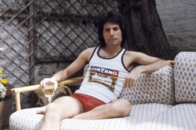 Posed portrait of Freddie Mercury, Cinzano vest and shorts. Photo by Ian Dickson/Redferns