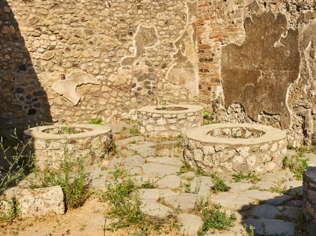 Bases for a roman stone hand mills (mola asinarae) of a bakery at Ruins of Pompeii. The city was an ancient Roman city destroyed by the volcano Vesuvius. Pompei, Campania, Italy.