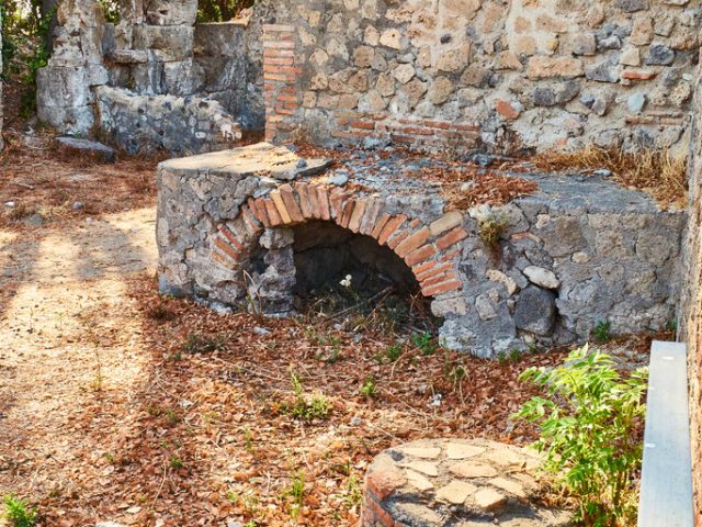 Roman kitchen of a Thermopolium in Via Consolare street at Ruins of Pompeii. The city was an ancient Roman city destroyed by the volcano Vesuvius. Pompei, Campania, Italy.